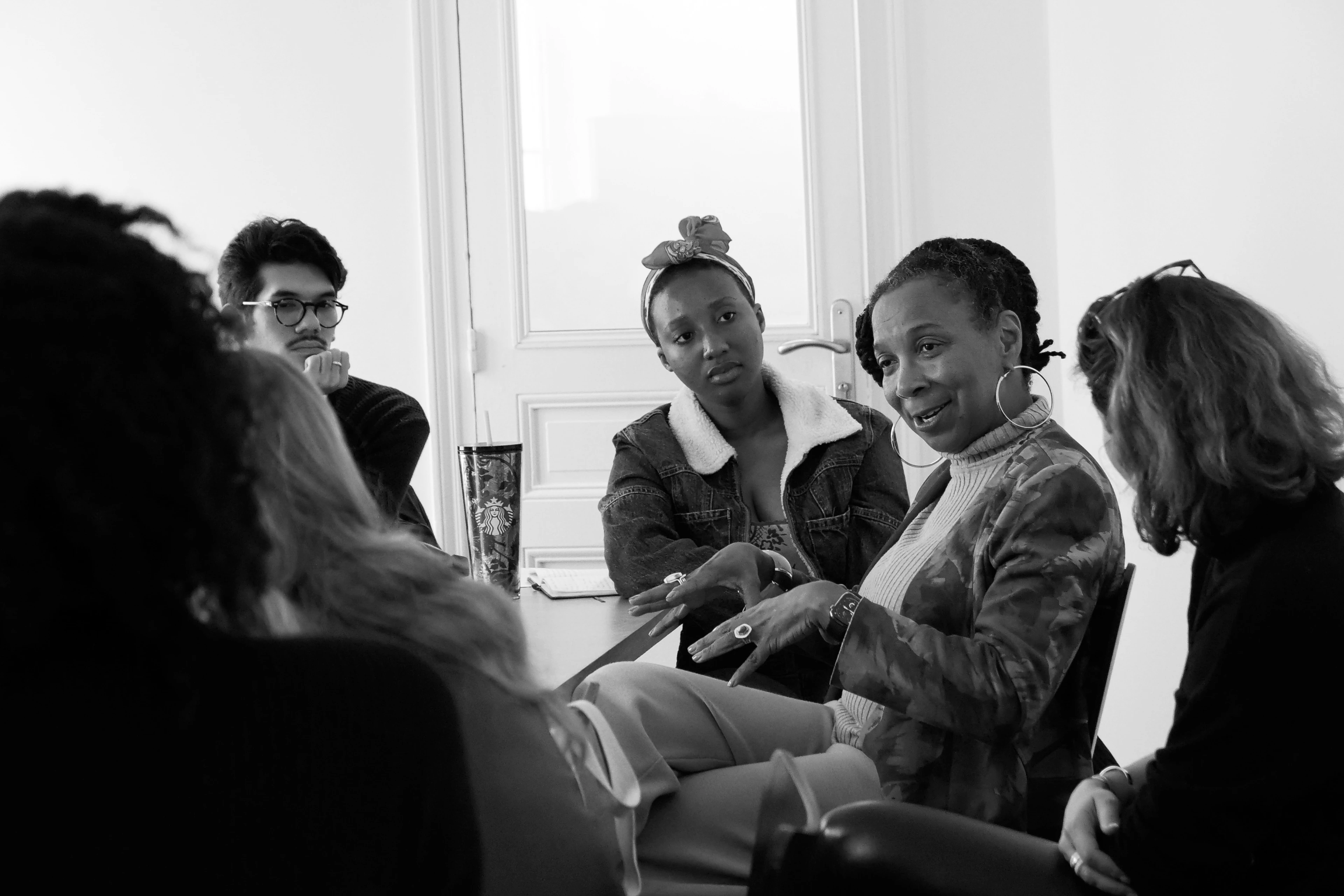 A diverse group of individuals engaged in a lively conversation while seated around a table.