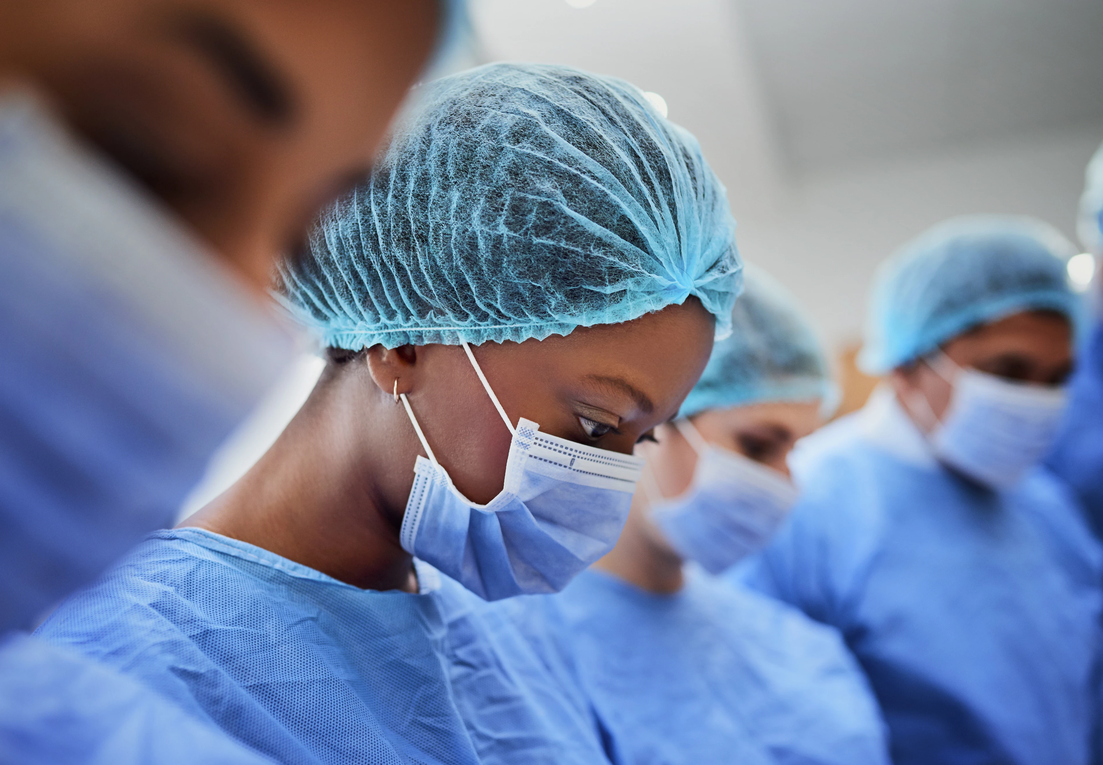 Surgeons in scrubs focused on a monitor during a medical procedure.